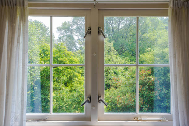 istock Beautiful cozy window with green forest view and white curtains. 976226474
