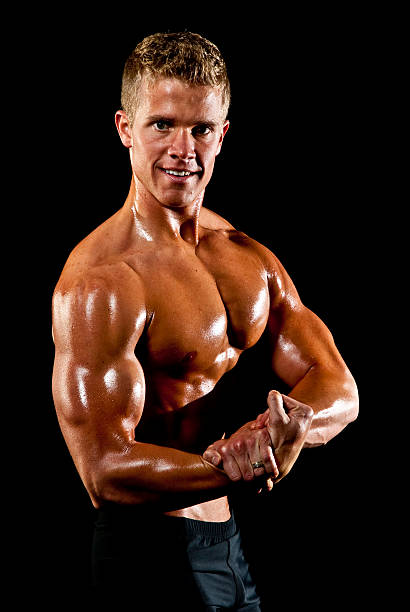 Male Fitness Model Flexing Right Arm Muscles stock photo