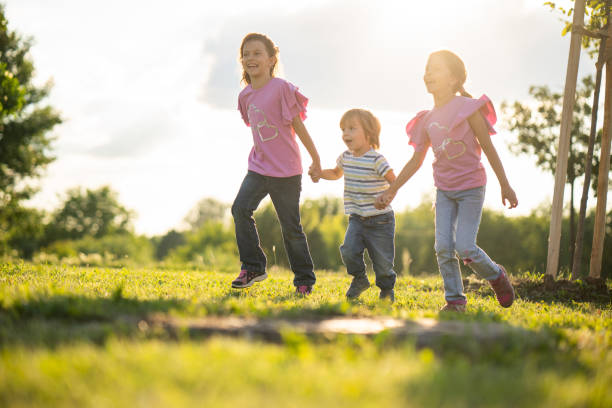 istock Sisters holding brother to hands and running 976255114