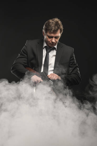istock Handsome middle aged man gangster with Thompson machine gun on dark background 976257368