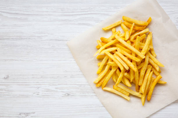 istock French fries over white wooden background, from above. Copy space. 976294440