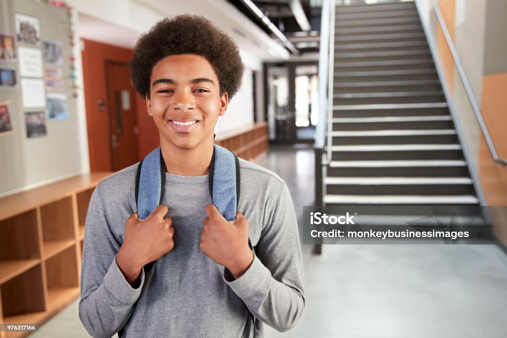 Porträt von männlichen High-School-Schüler, die über eine Treppe im College Gebäude stehen - Lizenzfrei Lernender Stock-Foto