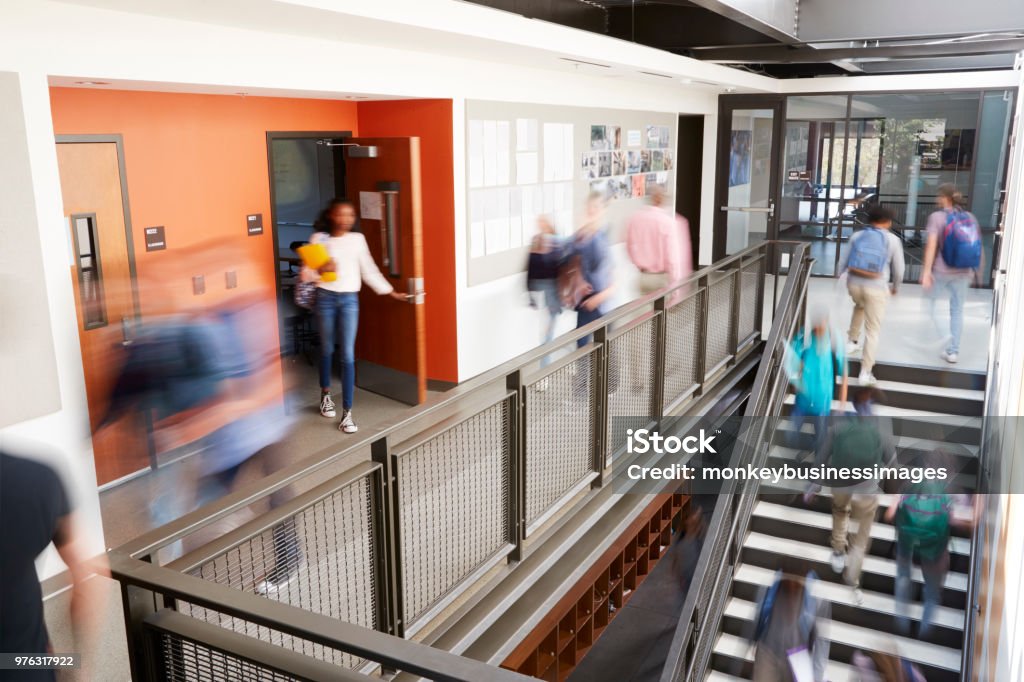 Zajęty korytarz szkoły średniej podczas przerwy z rozmytymi uczniami i personelem - Zbiór zdjęć royalty-free (Wykształcenie)