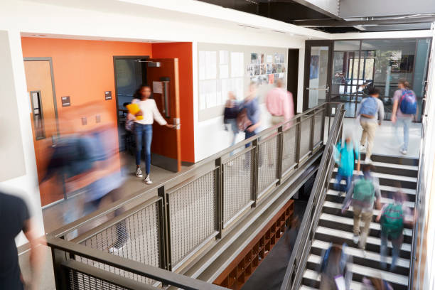 busy high school corridor during recess with blurred students and staff - átrio imagens e fotografias de stock