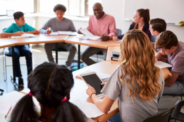 istock Female High School Student Using Digital Tablet Whilst Sitting At Desk In Class 976321514