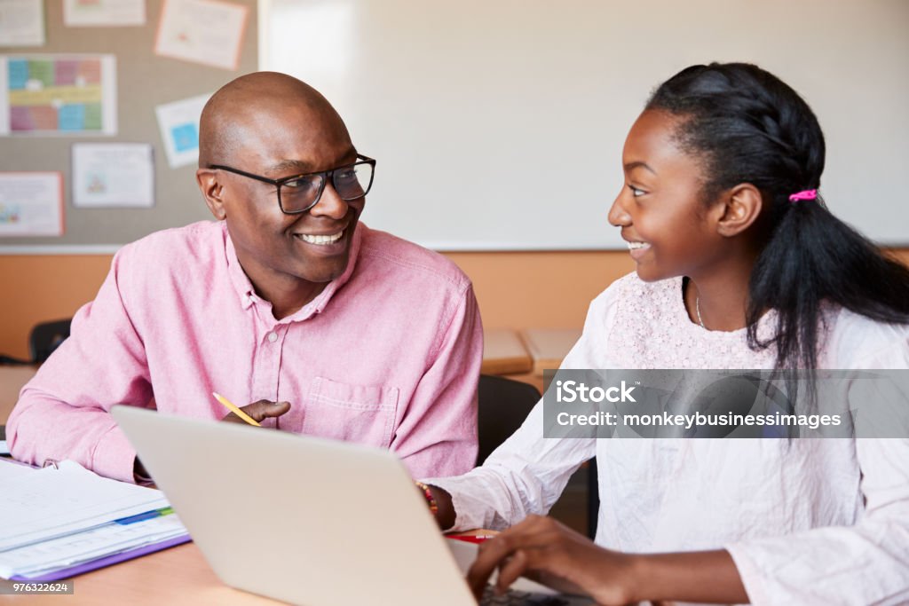 High School Tutor Giving Female Student One To One Tuition At Desk Teacher Stock Photo