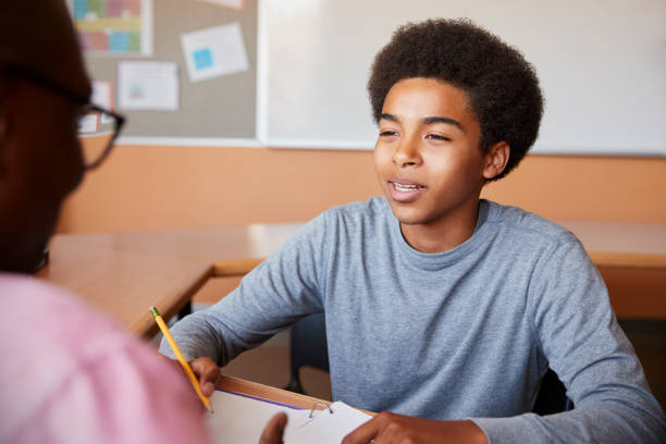 istock High School Tutor Giving Male Student One To One Tuition At Desk 976323034