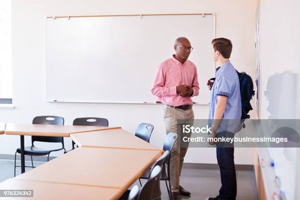 High School Tutor Talking With Male Student After Class Stock Photo - Download Image Now