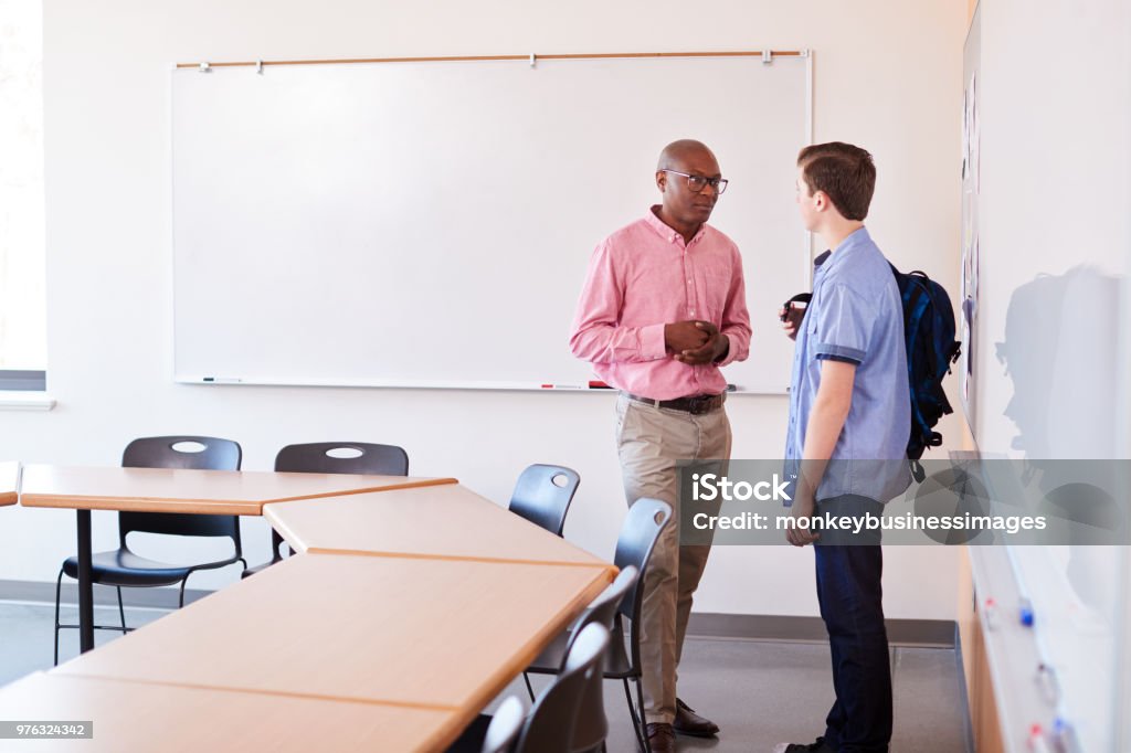 Escola secundária Tutor falando com estudante do sexo masculino, depois da aula - Foto de stock de Professor royalty-free