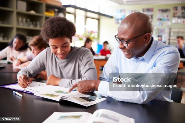 Tutor Del Liceo Seduto Alla Scrivania Con Studente Maschio In Classe Di Biologia - Fotografie stock e altre immagini di Insegnante