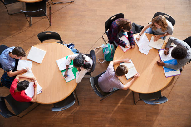 istock Overhead Shot Of High School Pupils In Group Study Around Tables 976330350