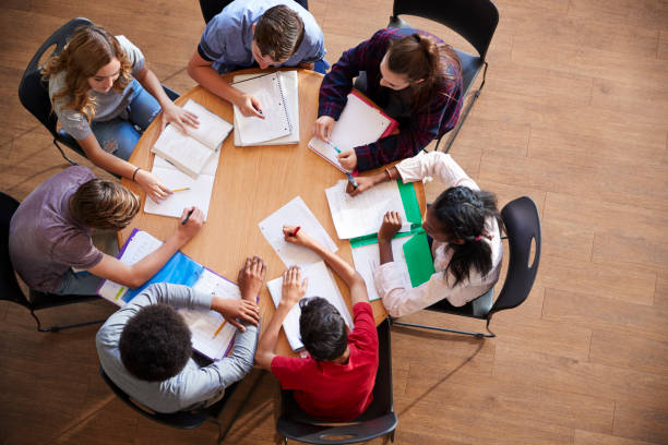 istock Overhead Shot Of High School Pupils In Group Study Around Tables 976330916