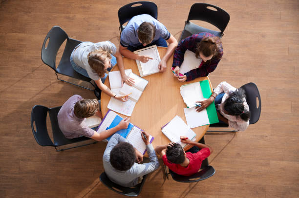 istock Overhead Shot Of High School Pupils In Group Study Around Tables 976330926