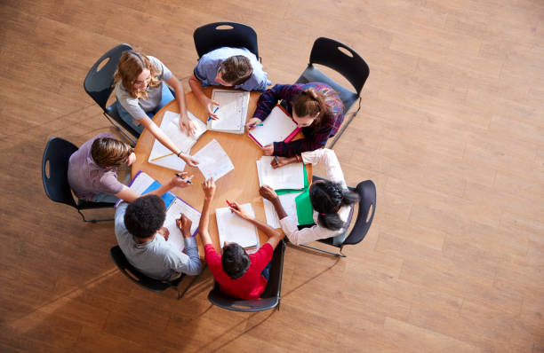 istock Overhead Shot Of High School Pupils In Group Study Around Tables 976330930