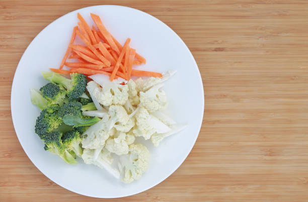 istock Cauliflower, broccoli and carrots on a plate isolated on white background. 976340684