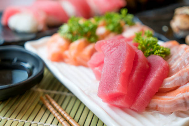 sashimi di pesce a fette miste in piatto bianco. salmone sashimi e tonno con tonno, caviale volante per uova di pesce e primo piano del foie gras. menu ristorante giappone - caviar salmon red gourmet foto e immagini stock