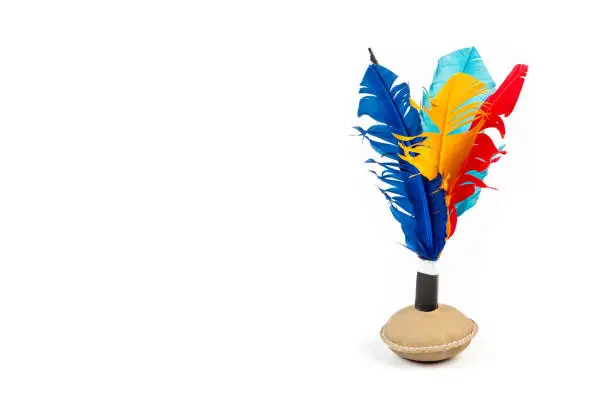 Photo of Close up of handmade shuttlecock toy with colourful feathers on white background.
