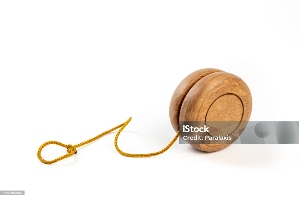 Close up of a wooden yo-yo with yellow string on white background. objects - toys - shoot in studio Yo-yo Stock Photo