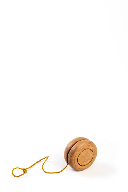 istock Close up of a wooden yo-yo with yellow string on white background. 976395500