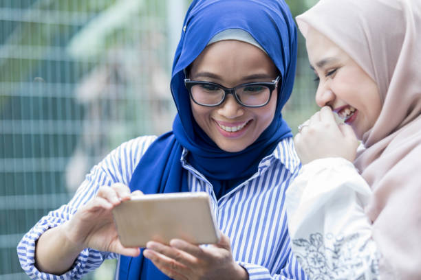 istock Female friends look at something on digital tablet 976424258