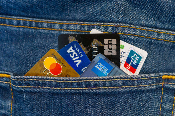 cartes de crédit dans la poche de jeans - american express photos photos et images de collection