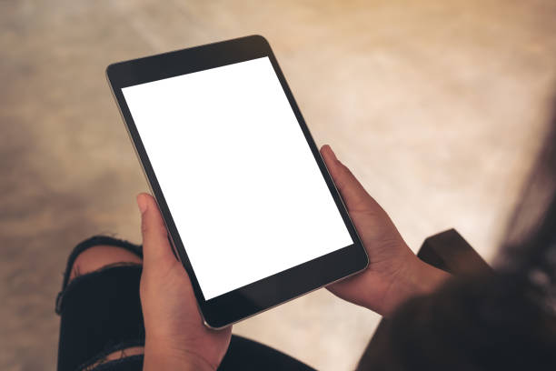 istock Mockup image of woman holding black tablet pc with blank white desktop screen 976460162