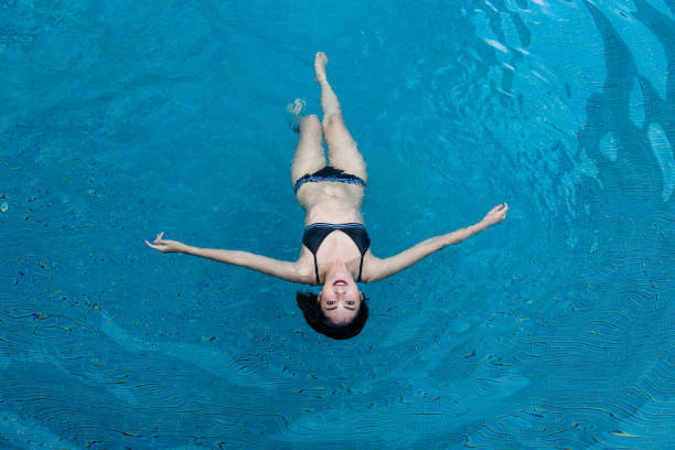 istock asian lady in swimming suite posting water pool. 976460260