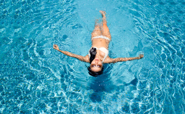 istock sexy swimming lady with bikini suite floating on water 976464880