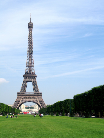 The Arc de Triomphe de Carrousel in Paris France, in the foreground are tourists walking from the Louvre museum.