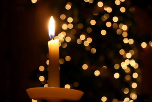 Advent white candles with decor in shiny lights closeup