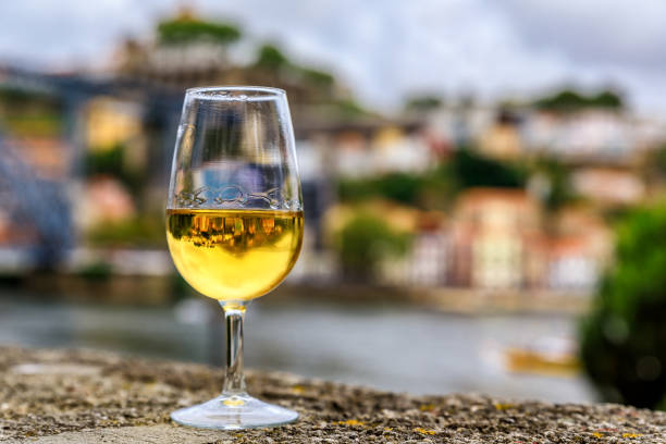verre de vin de porto avec la physionomie floue de porto portugal en arrière-plan - portugal port wine porto the douro photos et images de collection