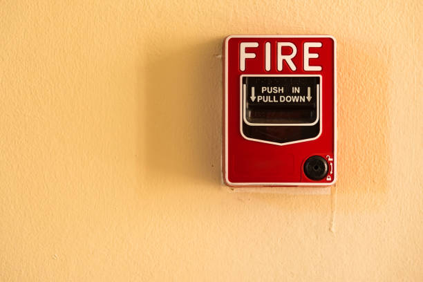 istock Fire break glass alarm switch on the cement wall. 976489924
