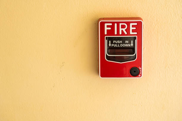 istock Fire break glass alarm switch on the cement wall. 976489926