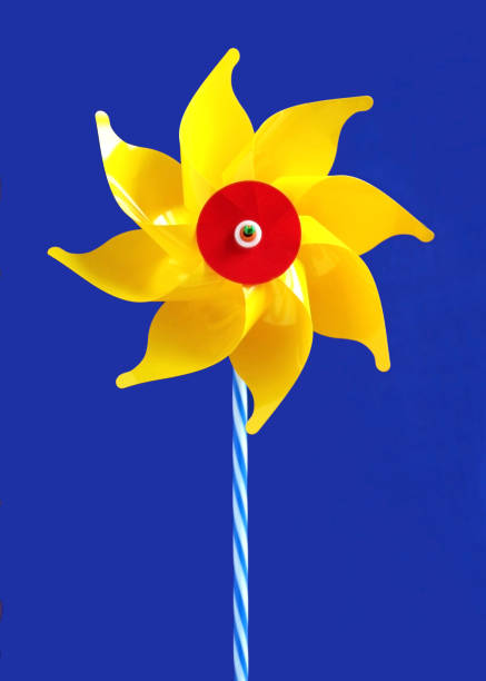 istock yellow pinwheel, blue sky 976522730