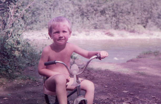 Kid riding on a three-wheeled bicycle. stock photo