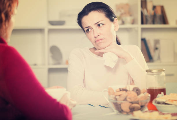 istock Unhappy female talking with mother at table 976548548