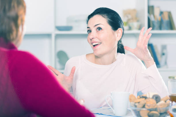 istock Happy young woman talking with mother at table 976548552