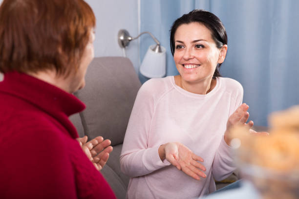 istock Mature woman and daughter talking at sofa 976548616