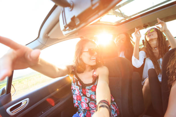 istock Cheerful girlfriends traveling with a car 976554976