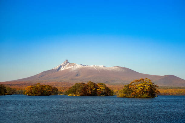 Beautiful view of Mt. Komagatake taken from Onuma park, Hakodate, Hokkaido, Japan. During autumn season with clear blue sky. stock photo