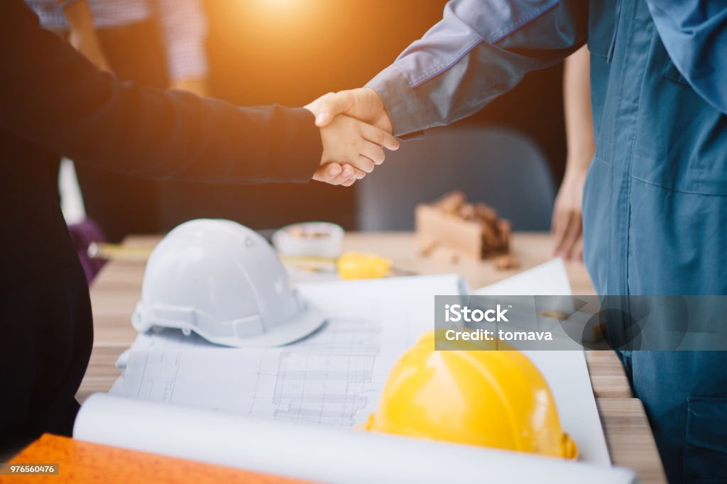 Businessman and engineer handshake closing a deal in construction site. Sucessful,engineering and business concept. Construction Industry Stock Photo