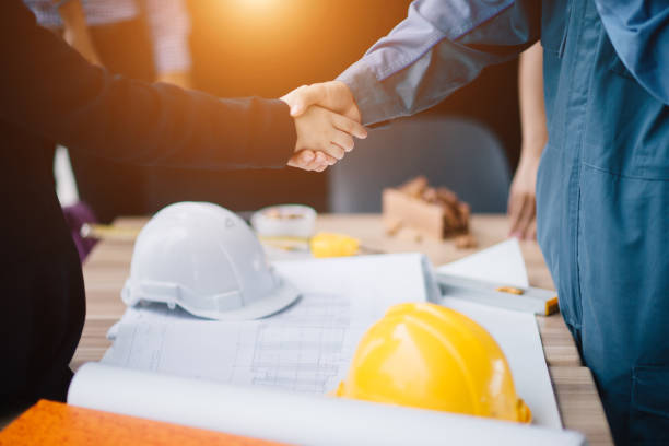 empresário e engenheiro handshake de fechar um negócio no canteiro de obras. sucessful, engenharia e conceito de negócio. - oil business - fotografias e filmes do acervo