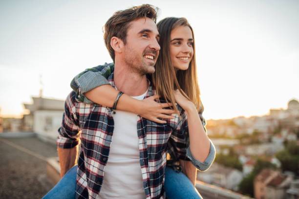 istock Handsome man holding a woman on his back 976566176