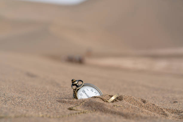 A beautiful swiss wrist watch lying in the sand. Markings removed.