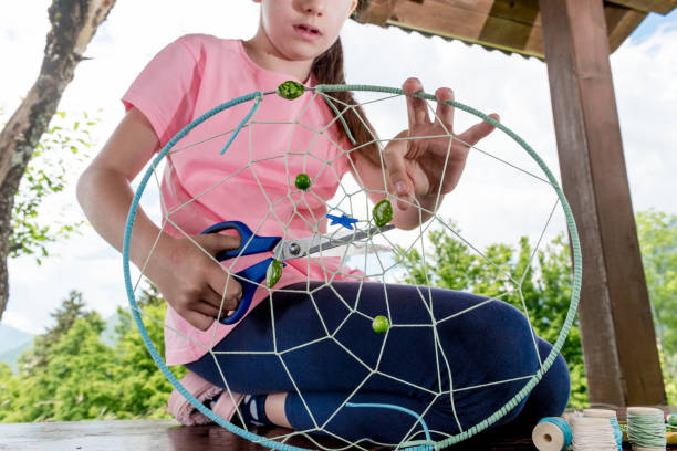 istock Girl Making Summer Dream Catcher 976573078