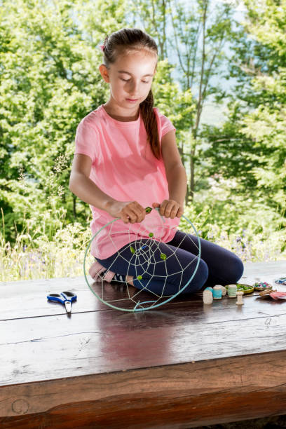istock Girl Making Summer Dream Catcher 976573082