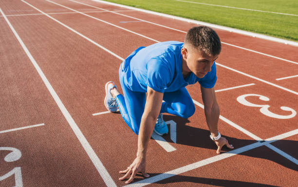 開始位置、レースを開始する準備ができての若い選手は男性の水平方向ショット。男スプリンター スポーツ運動競技場で競馬場の準備ができて。スポーツ、ライフ スタイル、人々 の概念。 - starting line competition running jogging ストックフォトと画像