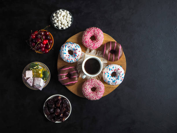 Donut sweets and Turkish sweets on a black table with copy space