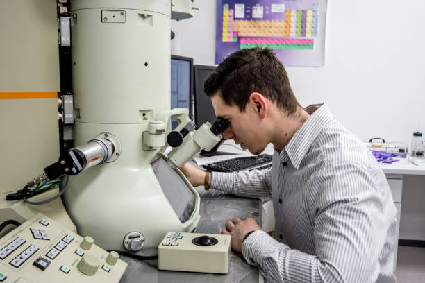 Male Scientist Looking Inro Field Emission Electron Microscope
