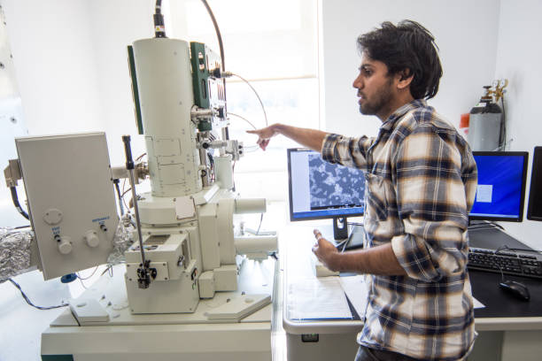 istock Male Scientist Making Adjustments to Field Emission Electron Microscope 976578634